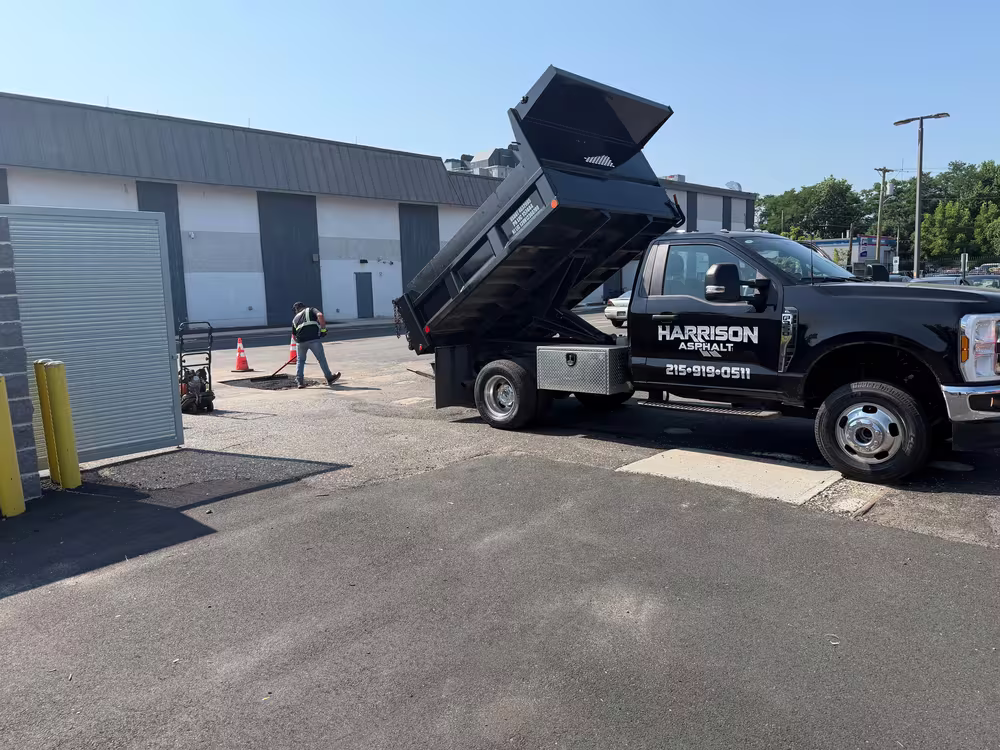 Harrison truck tipping hot mix at an industrial unit