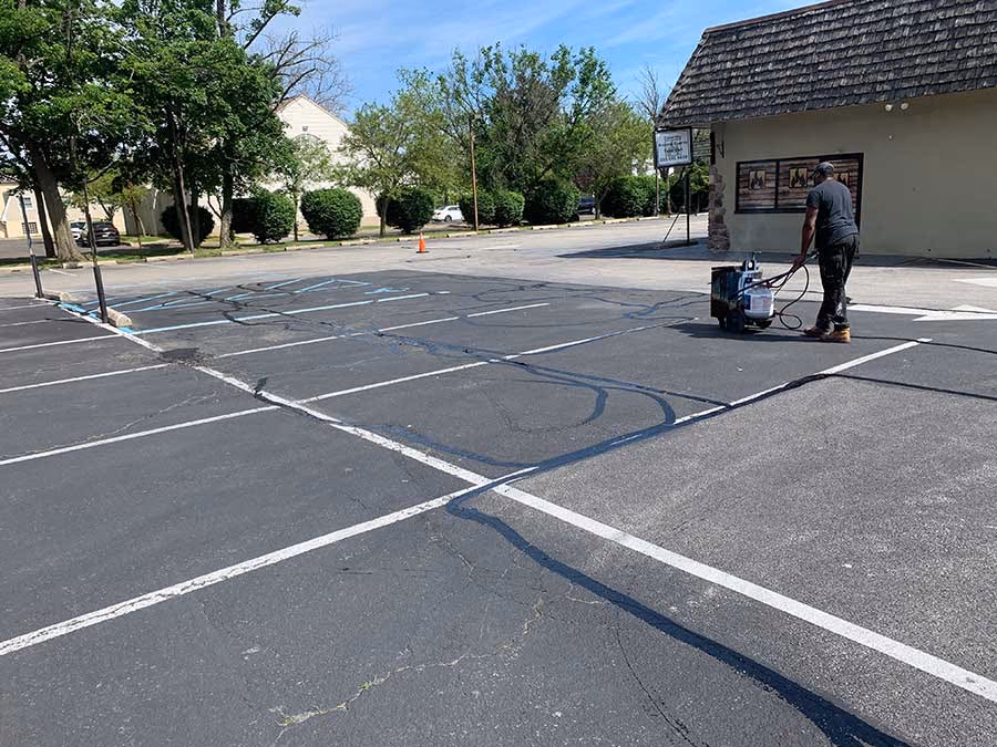 Crack sealing a striped commercial lot
